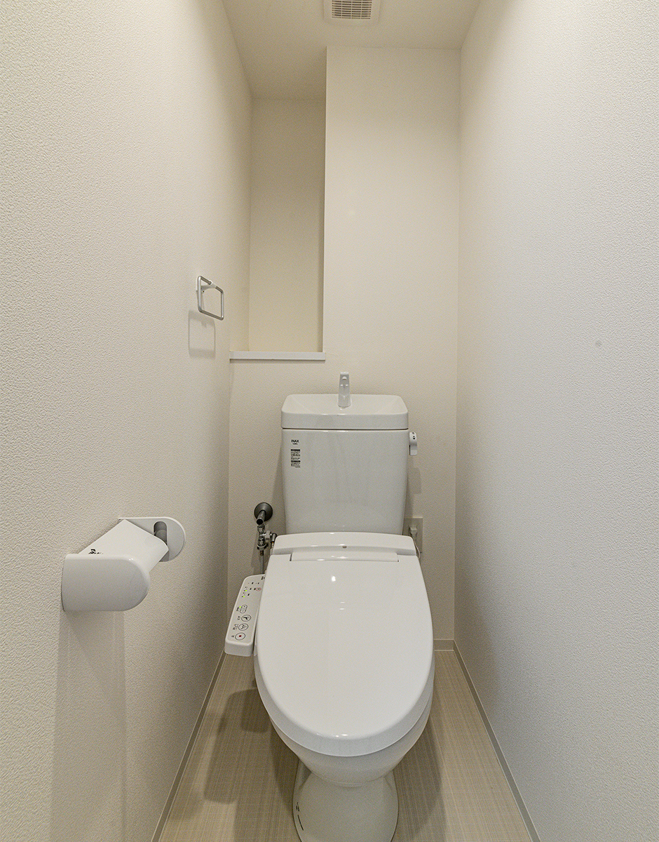 名古屋市天白区の300坪土地活用：4階建て賃貸マンションの棚とタオルハンガーの付いたトイレ