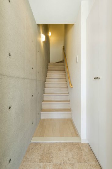 名古屋市西区の全室角部屋2階建て賃貸マンションのコンクリート打ちっぱなしの壁のある玄関ホール