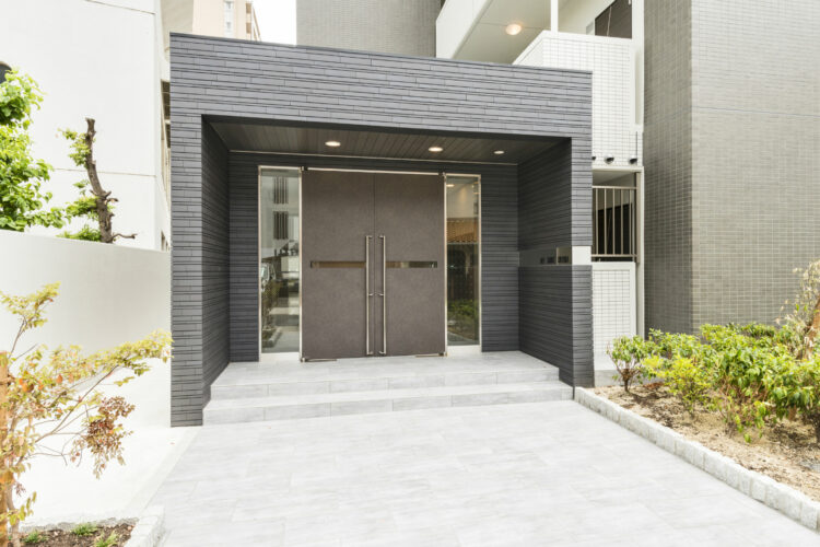 名古屋市中区の賃貸マンションの植栽が両側にある玄関アプローチと高級感あるエントランス