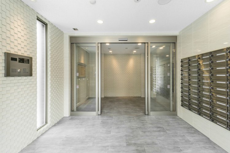 名古屋市中区のワンルーム賃貸マンションの白いエンボス加工の壁がおしゃれなメールボックス付きエントランスホール　