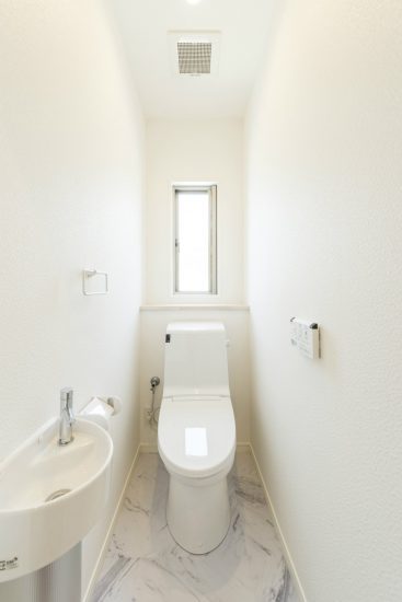 名古屋市名東区の戸建賃貸住宅の窓と手洗い場付きの真っ白なトイレ