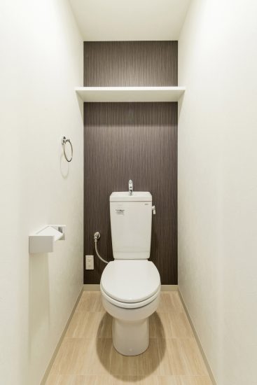 名古屋市名東区の賃貸マンションのアクセントクロスが1面についた棚付きトイレ