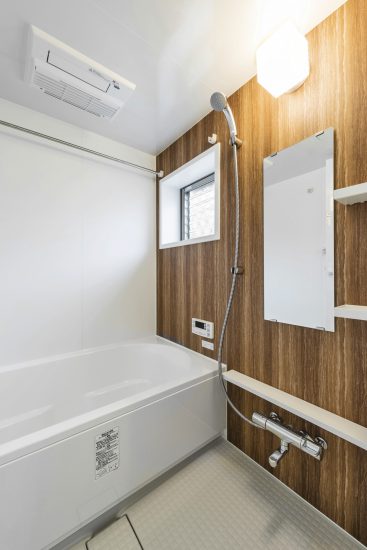 名古屋市北区のメゾネット賃貸アパートの木目模様の壁のあるゆったりとしたお風呂場