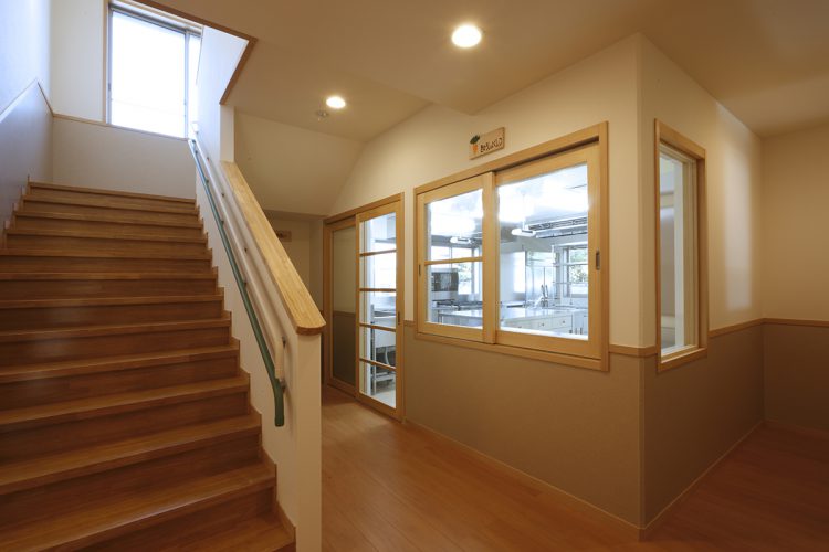 名古屋市千種区の保育施設の手すり付きの階段と廊下から見える調理室