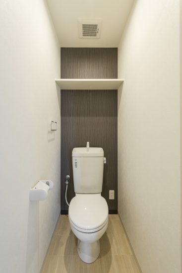 名古屋市熱田区の全室角部屋3階建て賃貸マンションのタオルハンガーと棚付きトイレ