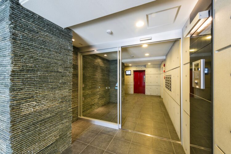 名古屋市名東区の賃貸マンションの赤のエレベータの扉が目を引くエントランスホール