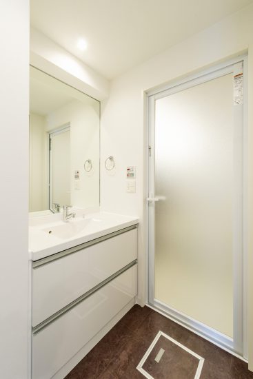 名古屋市西区の賃貸マンションの白い壁とダークブラウンの床がおしゃれな洗面室