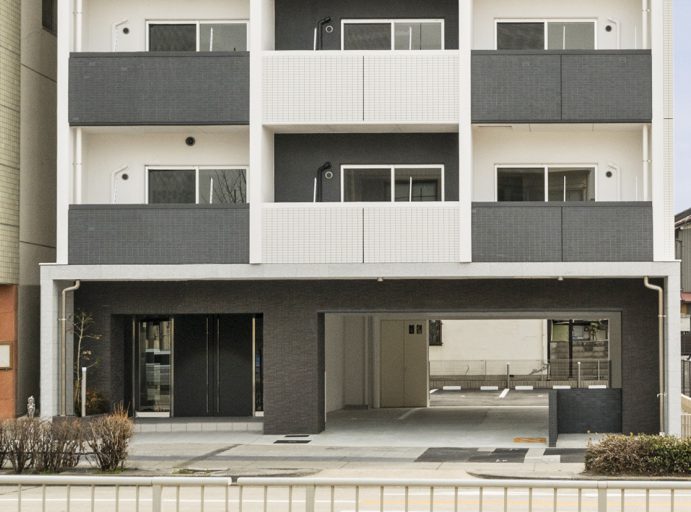 名古屋市瑞穂区の賃貸マンションの駐車場が奥にあるモノトーンの外観デザイン