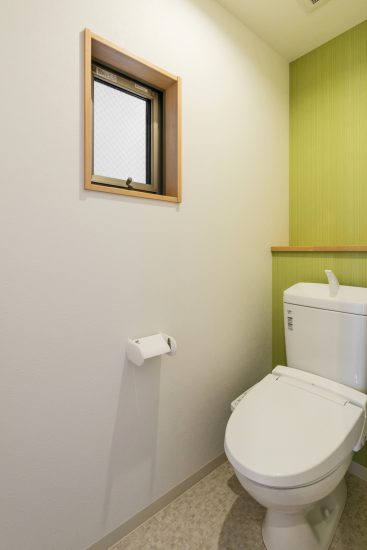 名古屋市名東区の戸建賃貸住宅の緑色のアクセントクロスがおしゃれな棚＆窓付きトイレ