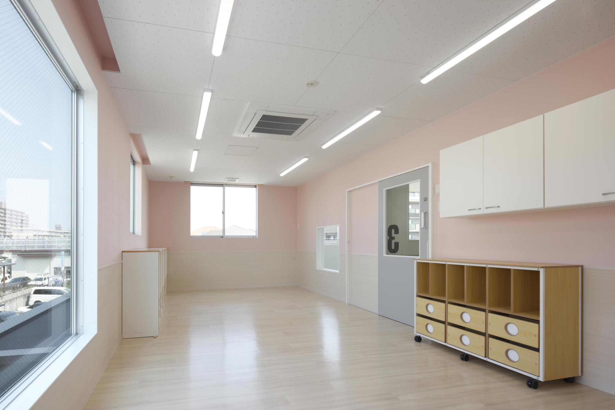 名古屋市天白区の保育施設の大きな窓があり明るいピンク色の保育室