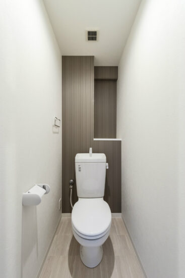 棚のあるシンプルなデザインのトイレ