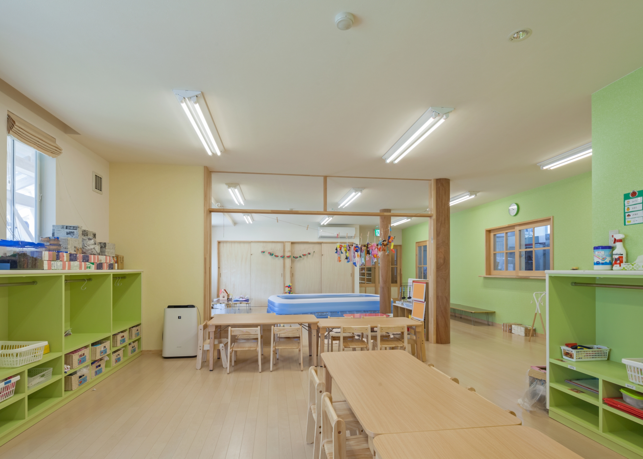 名古屋市緑区の保育施設の緑色の壁と収納棚のある保育室