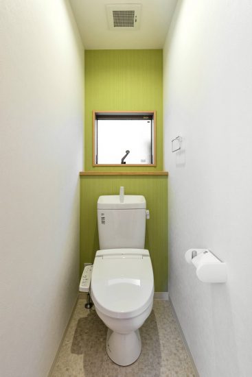 名古屋市北区のメゾネット賃貸アパートの緑色のアクセントクロスがおしゃれな窓付きトイレ