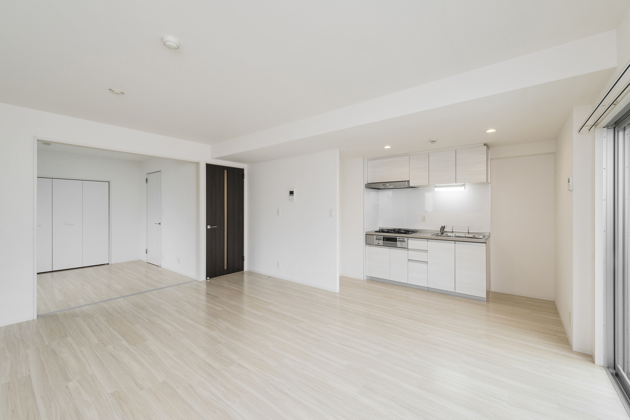 名古屋市中区の賃貸マンションのドアがアクセントカラーの白を基調にしたLDK･洋室