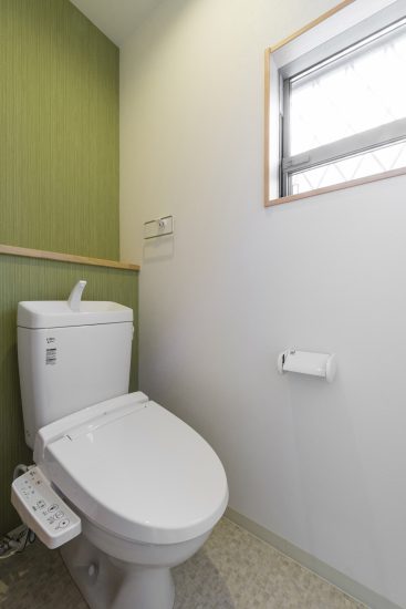 名古屋市千種区の戸建賃貸住宅の緑のアクセントカラーがおしゃれな棚＆窓付きトイレ