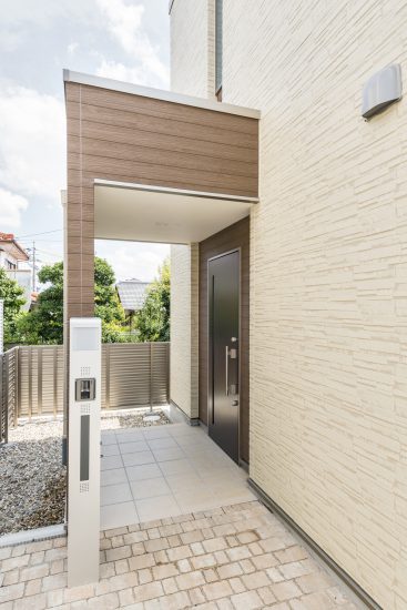 名古屋市千種区の戸建賃貸住宅の凹凸のある壁とスリットのあるドアがおしゃれな玄関