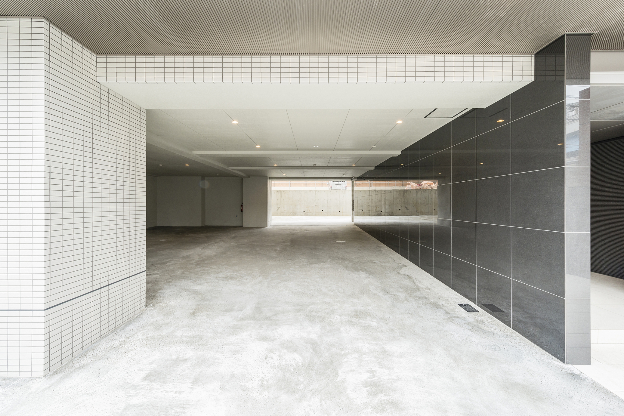 名古屋市名東区の賃貸マンションの光沢のあるタイル壁がある屋内駐車場
