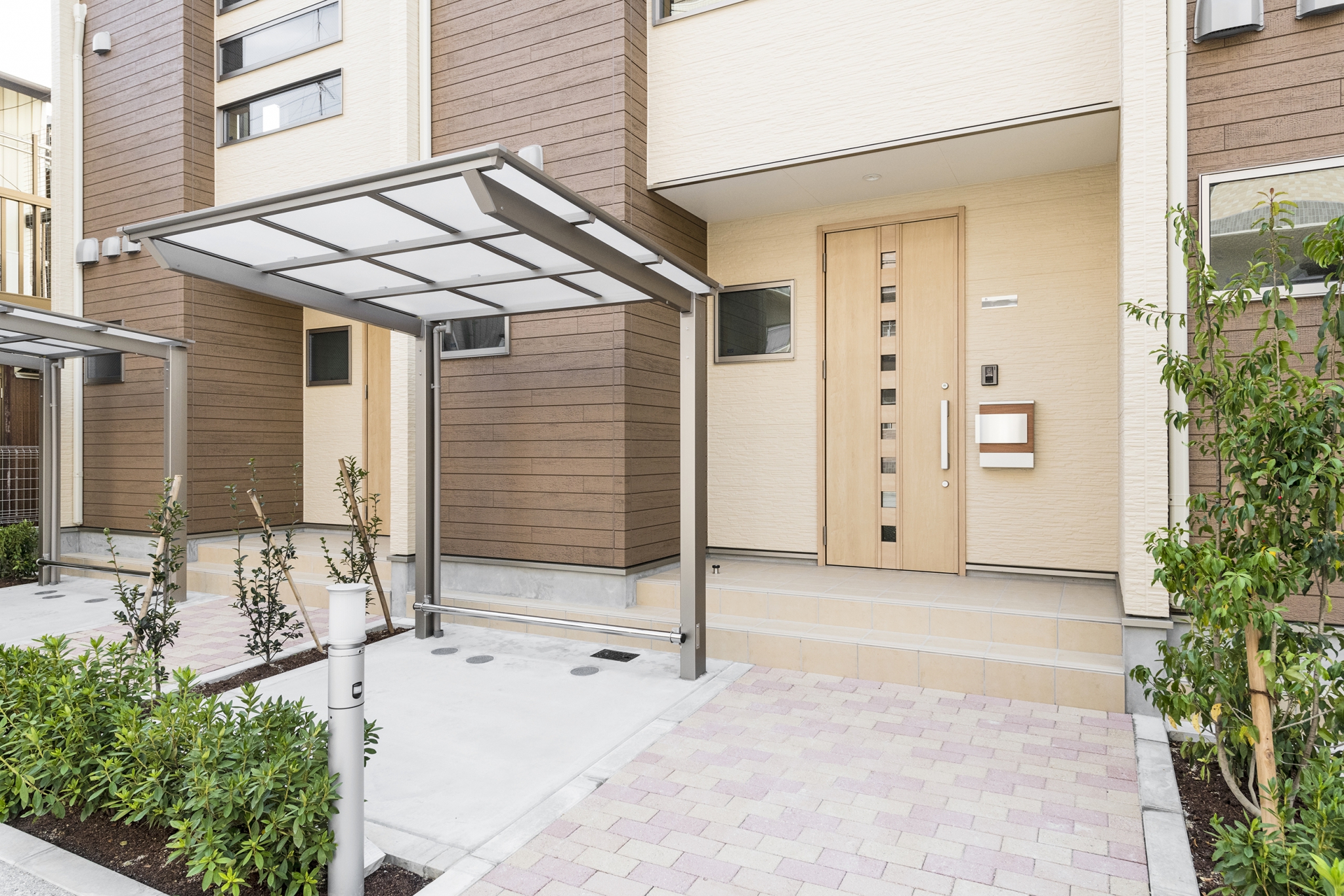 名古屋市中川区のメゾネット賃貸アパートの植栽のあるエントランスと屋根付きの駐輪場