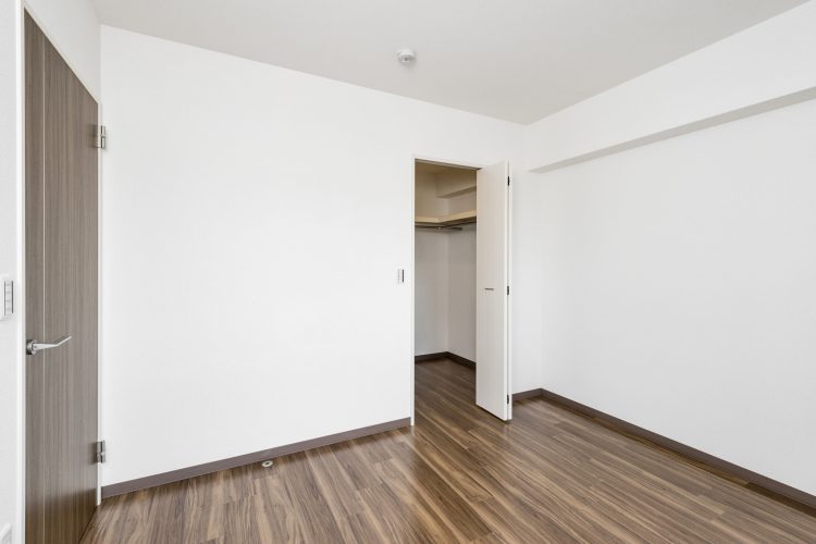 名古屋市天白区の賃貸マンションのダークブラウンのフローリングとドアがアクセントの洋室