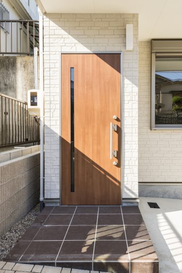 名古屋市名東区のメゾネットアパートのスリットのある木目調の玄関ドア