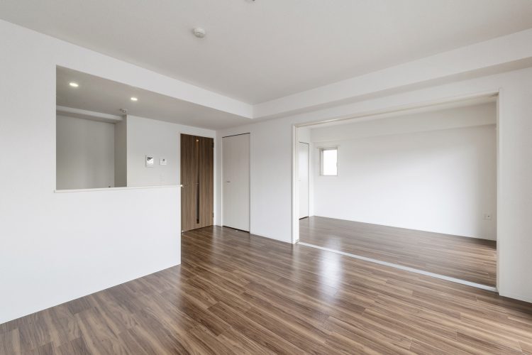 名古屋市名東区の4階建ての賃貸マンションの木目調のフローリングがアクセントのリビングダイニングと洋室