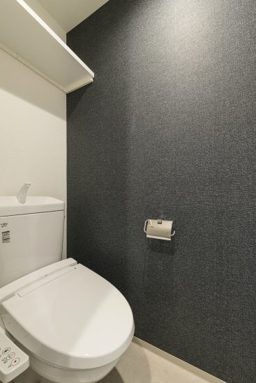 名古屋市中区のワンルーム賃貸マンションの黒の壁がアクセントになった棚付きのトイレ