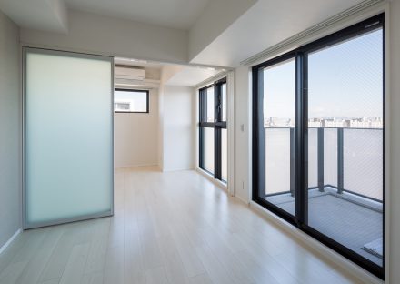 名古屋市北区のモダンな10階建賃貸マンションのバルコニー付き半透明のドアとパネルで明るい洋室
