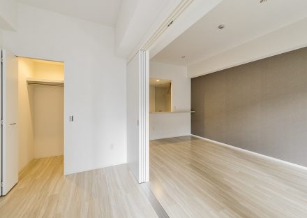 名古屋市中村区の賃貸マンションのウォークインクローゼット付きの洋室とリビングダイニングの新築写真
