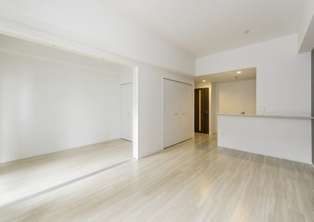 名古屋市中村区の賃貸マンションの白を基調としたリビングダイニングと洋室の新築写真