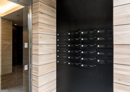 名古屋市中区の賃貸マンションの木目の壁に映えるブラックのメールボックス