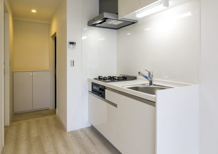 名古屋市昭和区の4階建て賃貸マンションのシューズボックスのついた玄関とコンパクトなキッチン