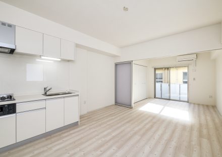 名古屋市昭和区の4階建て賃貸マンションの白いキッチンのついたLDKと洋室