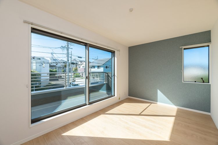 名古屋市名東区のシンプルなデザインの注文住宅のバルコニーの付いた明るい洋室