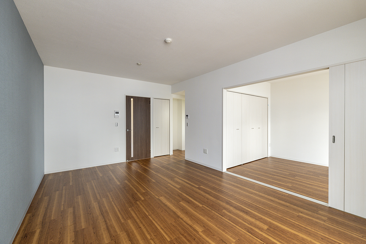 名古屋市名東区の3階建て賃貸マンションのアクセントカラーの壁のあるLDKと収納付きの洋室
