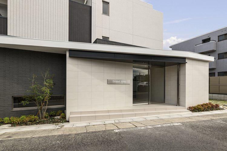 名古屋市名東区の3階建て賃貸マンションの植栽が左右にあるエントランス