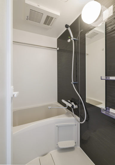 名古屋市天白区の10階建て賃貸マンションのダークなアクセントカラーの壁のあるコンパクトな浴室
