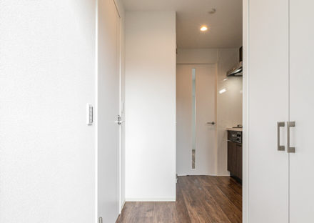 名古屋市東区の11階建てワンルームマンションの木目調の床とキッチンパネルがおしゃれな玄関