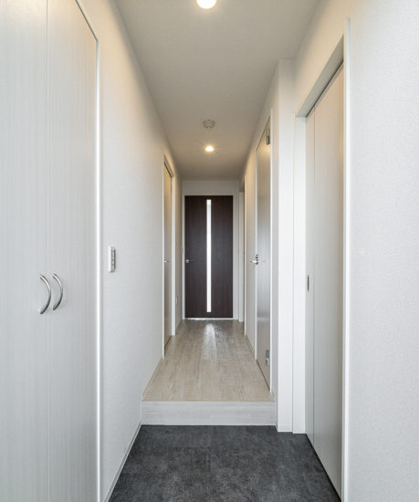 名古屋市瑞穂区のナチュラルカラーの外観デザイン7階建て賃貸マンションの白色の壁にリビングへのドアがアクセントカラーの玄関