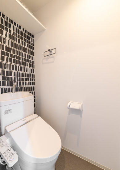 名古屋市東区の11階建てワンルームマンションのモダンな壁紙がアクセントのトイレ