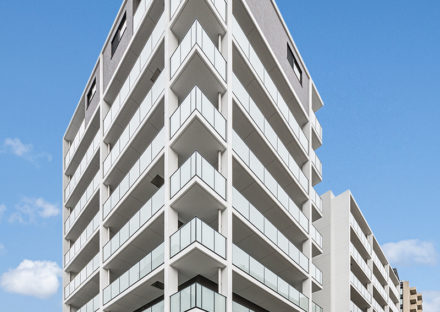 名古屋市昭和区の賃貸併用住宅の半透明の手すりパネルが並ぶ外観デザイン