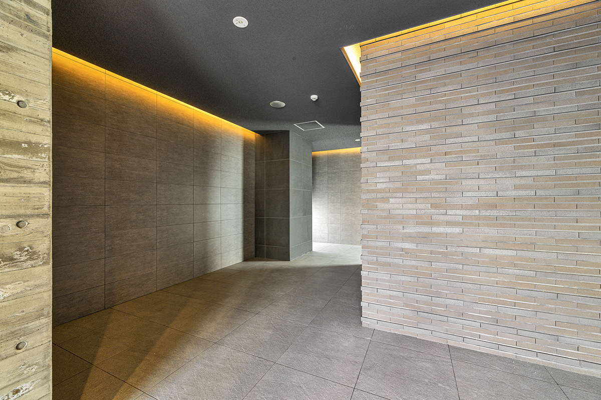 愛知県豊田市の12階建ての賃貸マンションの凹凸のある壁がおしゃれなエントランスホール
