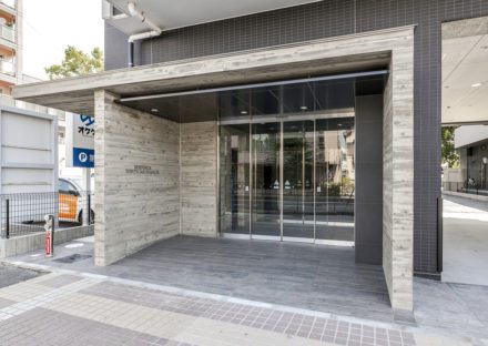 愛知県豊田市の12階建ての賃貸マンションのトーンを抑えた高級感のあるエントランス