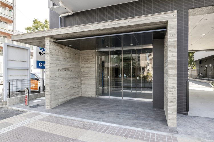 愛知県豊田市の12階建ての賃貸マンションのトーンを抑えた高級感のあるエントランス
