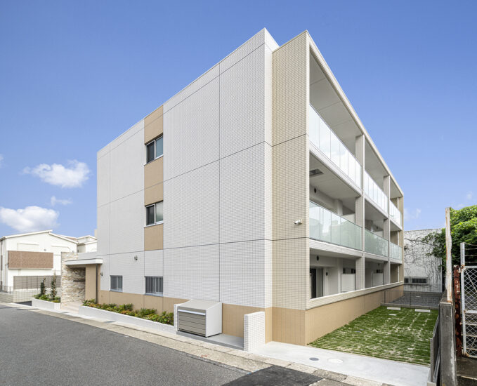 名古屋市名東区のナチュラルなデザインの3階建て賃貸マンションの裏の駐車場にも緑があるナチュラルカラーな外観