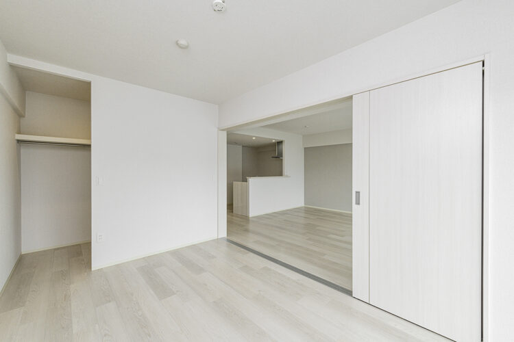 名古屋市名東区のナチュラルなデザインの3階建て賃貸マンションのウォークインクローゼット付きのLDKと繋がる洋室