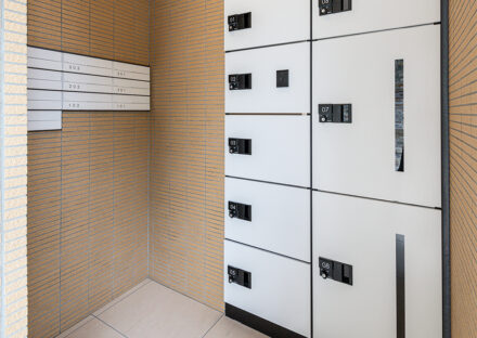 名古屋市名東区のナチュラルなデザインの3階建て賃貸マンションの白色のメールコーナーと宅配ボックス