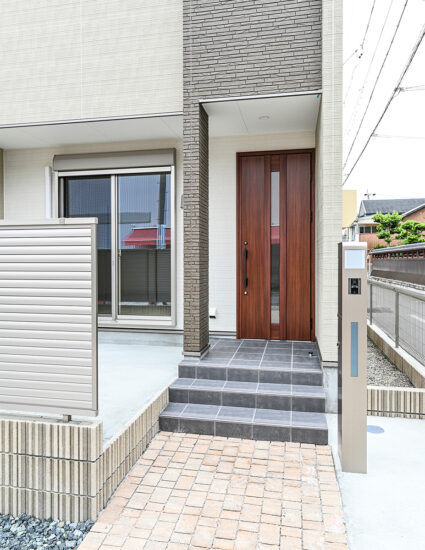 名古屋市中村区の戸建賃貸住宅の木目調のドアとタイルがおしゃれな玄関