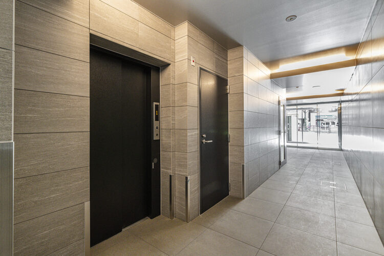 愛知県名古屋市千種区のモダンな賃貸マンションの大判タイルの高級感あるエレベーターホール