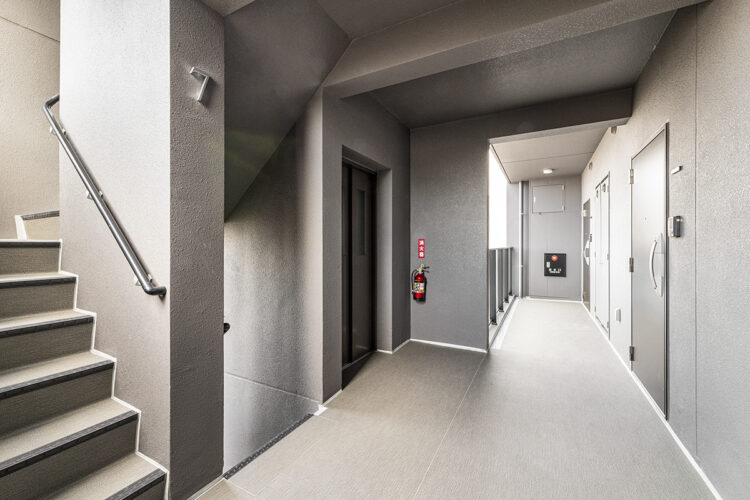 名古屋市昭和区の12階建て高級感ある賃貸マンションのおしゃれなデザインの玄関ドアのある共用廊下