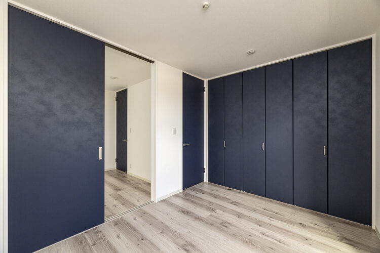 愛知県一宮市の戸建賃貸住宅のLDKの扉の色と合わせた青色の扉の一面に収納の付いた洋室